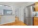 Kitchen with stainless steel refrigerator, open to living area, and wood flooring at 7112 Benhart Dr, Raleigh, NC 27613