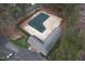 Aerial view of covered pool and pool house with surrounding trees and a parking area at 7112 Benhart Dr, Raleigh, NC 27613