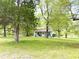 Quaint home surrounded by mature trees and lush greenery at 808 E Hanover Rd, Graham, NC 27253