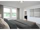 Spacious bedroom with a large bed, two windows with curtains, and an ensuite bathroom at 817 Kenyon Springs Dr, Zebulon, NC 27597
