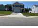 Charming two-story home with gray siding, a well-manicured lawn, and an attached two-car garage at 817 Kenyon Springs Dr, Zebulon, NC 27597