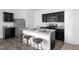 Kitchen features granite countertops, dark cabinetry, stainless steel appliances and three barstools at 817 Kenyon Springs Dr, Zebulon, NC 27597