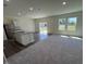 Open living area with an island kitchen featuring granite countertops and stainless steel appliances, leading to an outdoor patio at 817 Kenyon Springs Dr, Zebulon, NC 27597