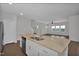 Open kitchen featuring an island with a double sink and views into the living room and staircase at 82 White Ash Dr, Clayton, NC 27527