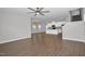 Open-concept living area featuring hardwood floors, neutral walls, modern ceiling fan, and a view of the kitchen at 82 White Ash Dr, Clayton, NC 27527