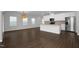 Open-concept living space with hardwood floors and a modern kitchen that has white cabinets and a large island at 82 White Ash Dr, Clayton, NC 27527