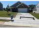 Charming single-story home featuring gray siding, brick accents, a well-manicured lawn, and a two-car garage at 821 Kenyon Spring Dr, Zebulon, NC 27597