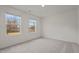 A comfortable carpeted bedroom with views of the outdoors through two large windows at 845 Kenyon Spring Dr, Zebulon, NC 27597