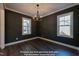 Elegant dining room with gray walls, dark wood floors, and modern chandelier lighting fixture at 85 Purslane Dr, Franklinton, NC 27525