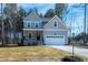 Charming two-story home with a well-manicured lawn and inviting front porch, next to a driveway and garage at 85 Purslane Dr, Franklinton, NC 27525