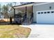 Welcoming front entrance with stone accents, covered porch, and a two-car garage with a concrete driveway at 85 Purslane Dr, Franklinton, NC 27525
