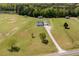 Aerial view of a home with a large lot, outbuildings, pond, and surrounded by trees at 850 Cheatham Mabry Rd, Henderson, NC 27537