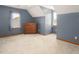Cozy bedroom featuring blue walls, plush carpeting, and natural light from two windows at 850 Cheatham Mabry Rd, Henderson, NC 27537
