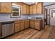 Cozy kitchen features wood cabinets, stainless steel dishwasher and hardwood floors at 850 Cheatham Mabry Rd, Henderson, NC 27537