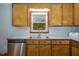 Cozy kitchen features wood cabinets, stainless steel dishwasher and hardwood floors at 850 Cheatham Mabry Rd, Henderson, NC 27537