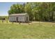 View of a barn on the property with metal roof, fenced yard, and natural surroundings at 850 Cheatham Mabry Rd, Henderson, NC 27537