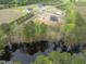 Aerial view of new home construction and partially wooded lot near pond at 8620 Dukes Lake Rd, Zebulon, NC 27597
