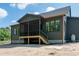Back of home shows a screened-in back porch with stairs descending to the yard at 8620 Dukes Lake Rd, Zebulon, NC 27597