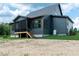Exterior view of home featuring a screened-in back porch, dark siding and green grass at 8620 Dukes Lake Rd, Zebulon, NC 27597