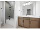 Well-lit bathroom showcasing a vanity, undermount sink, and shower with gray herringbone tile at 8620 Dukes Lake Rd, Zebulon, NC 27597