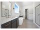 Bright bathroom featuring double sinks, bathtub, shower with glass door and a walk-in closet at 8620 Dukes Lake Rd, Zebulon, NC 27597