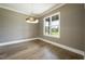 Bright dining room with hardwood floors, large window, and modern chandelier at 8620 Dukes Lake Rd, Zebulon, NC 27597