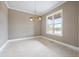Bright dining room with a modern chandelier and a large window offering scenic views at 8620 Dukes Lake Rd, Zebulon, NC 27597