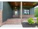 Inviting front porch features brick steps and wood columns with a stained wood ceiling at 8620 Dukes Lake Rd, Zebulon, NC 27597