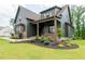 Beautiful two-story home with dark siding, brick accents, and well-manicured landscaping at 8620 Dukes Lake Rd, Zebulon, NC 27597