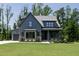 Craftsman home featuring a gray facade, manicured lawn and landscape, and attached garage at 8620 Dukes Lake Rd, Zebulon, NC 27597