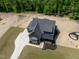 New home with a dark roof, gray siding and a beautiful green lawn surrounded by lush green trees at 8620 Dukes Lake Rd, Zebulon, NC 27597