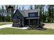 Beautiful home exterior with dark siding, brick accents, professional landscaping, and a manicured lawn at 8620 Dukes Lake Rd, Zebulon, NC 27597