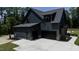 Exterior view features a two-car garage and dark gray siding, plus a concrete driveway at 8620 Dukes Lake Rd, Zebulon, NC 27597