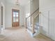 Inviting foyer with staircase, wood door with sidelight windows and decorative wall trim at 8620 Dukes Lake Rd, Zebulon, NC 27597