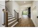 Elegant foyer with wood floors and staircase opens to the living room at 8620 Dukes Lake Rd, Zebulon, NC 27597