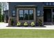 Up close view of a well-manicured gray home with brick base, mature shrubs, and walkway at 8620 Dukes Lake Rd, Zebulon, NC 27597