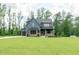 Beautiful craftsman-style home with gray siding, brick accents, copper gutters, and a well-manicured lawn at 8620 Dukes Lake Rd, Zebulon, NC 27597