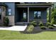 Front door entry featuring dark wood door, brickwork, and manicured flower beds at 8620 Dukes Lake Rd, Zebulon, NC 27597