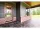 Inviting front porch showcasing a brick facade, textured concrete, wood door, and stylish exterior features at 8620 Dukes Lake Rd, Zebulon, NC 27597