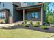 Charming front porch with wood columns and brick accents, enhanced by professional landscaping at 8620 Dukes Lake Rd, Zebulon, NC 27597