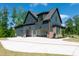 Spacious three-car garage with a long driveway and a partial view of the home's exterior at 8620 Dukes Lake Rd, Zebulon, NC 27597
