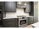 Gourmet kitchen featuring a stainless steel range, sleek gray cabinets, and stylish backsplash at 8620 Dukes Lake Rd, Zebulon, NC 27597