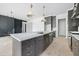 Modern kitchen island with built in sink, gray cabinets and stylish pendant lighting above at 8620 Dukes Lake Rd, Zebulon, NC 27597