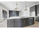 Modern kitchen island with gray cabinetry, light countertops, and a sink at 8620 Dukes Lake Rd, Zebulon, NC 27597