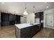 Open concept living room and kitchen, featuring modern lighting and a large kitchen island at 8620 Dukes Lake Rd, Zebulon, NC 27597
