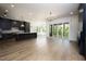 Open-concept living room with hardwood floors, dark kitchen cabinets, and glass doors at 8620 Dukes Lake Rd, Zebulon, NC 27597