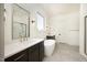 Bright bathroom featuring double vanity sinks, soaking tub, and walk-in shower at 8620 Dukes Lake Rd, Zebulon, NC 27597