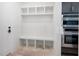 Bright mudroom with a built-in storage bench and shelving unit for organization at 8620 Dukes Lake Rd, Zebulon, NC 27597