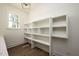 Well-organized pantry featuring built-in shelving, a window, and sleek wooden flooring at 8620 Dukes Lake Rd, Zebulon, NC 27597