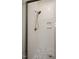 Shower featuring a mosaic tile floor, unique patterned wall tiles, and a bronze shower head fixture at 8620 Dukes Lake Rd, Zebulon, NC 27597